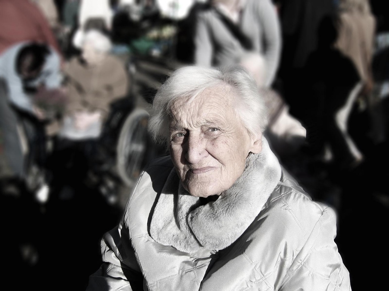 Close-up portrait of an elderly woman with white hair looking directly at camera.