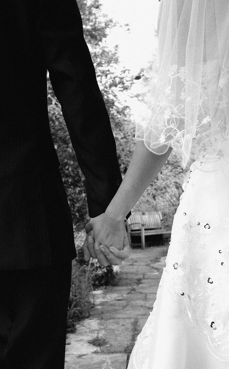 Maria and James holding hands, walking through a garden