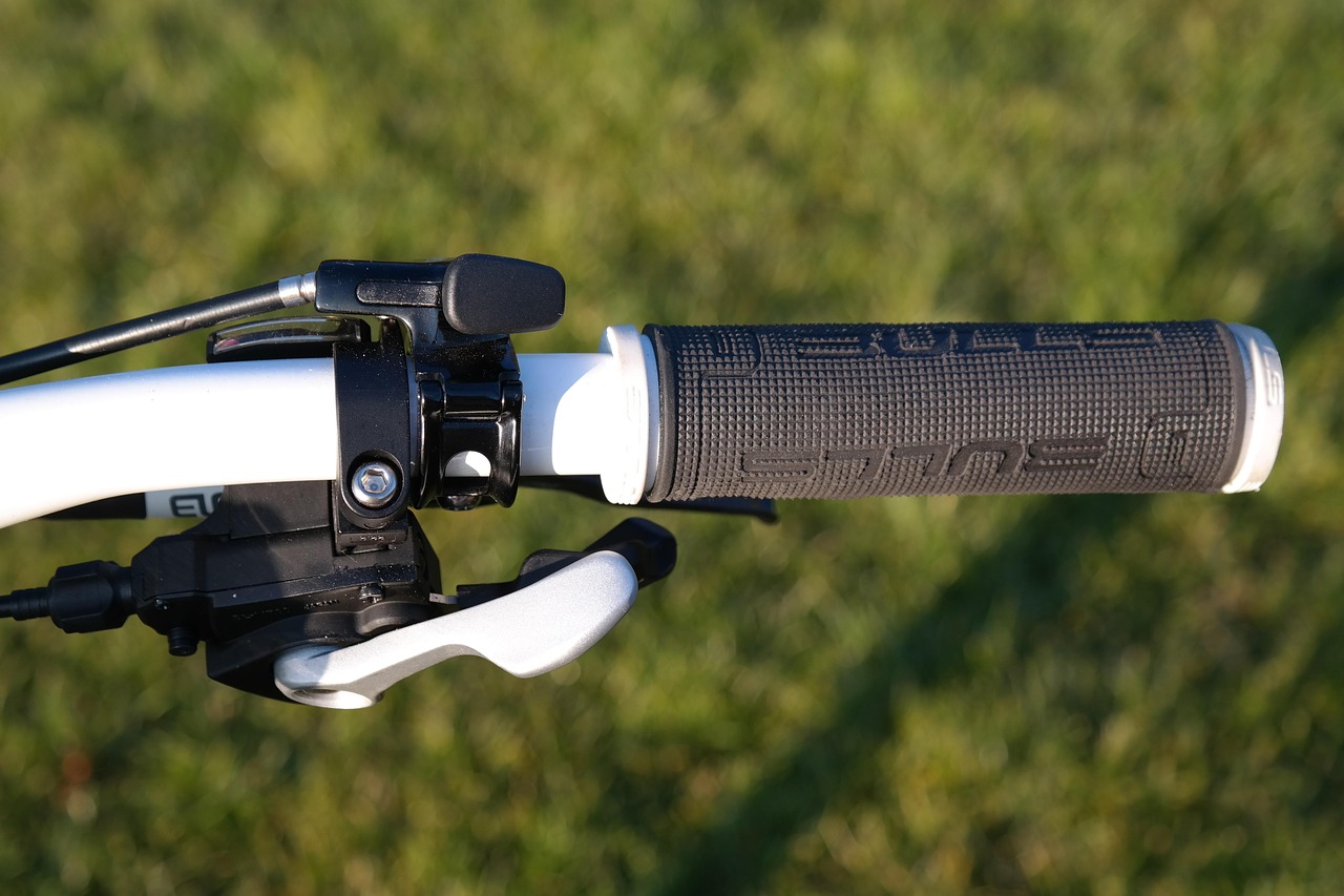 Close-up van een mountainbikestuur met rubberen grip, remhendel en shifter binnen bereik van een vinger