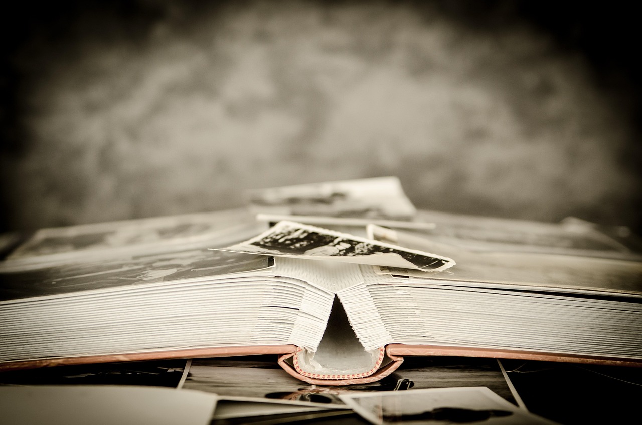 Open photo album showing old printed photographs arranged on its pages.