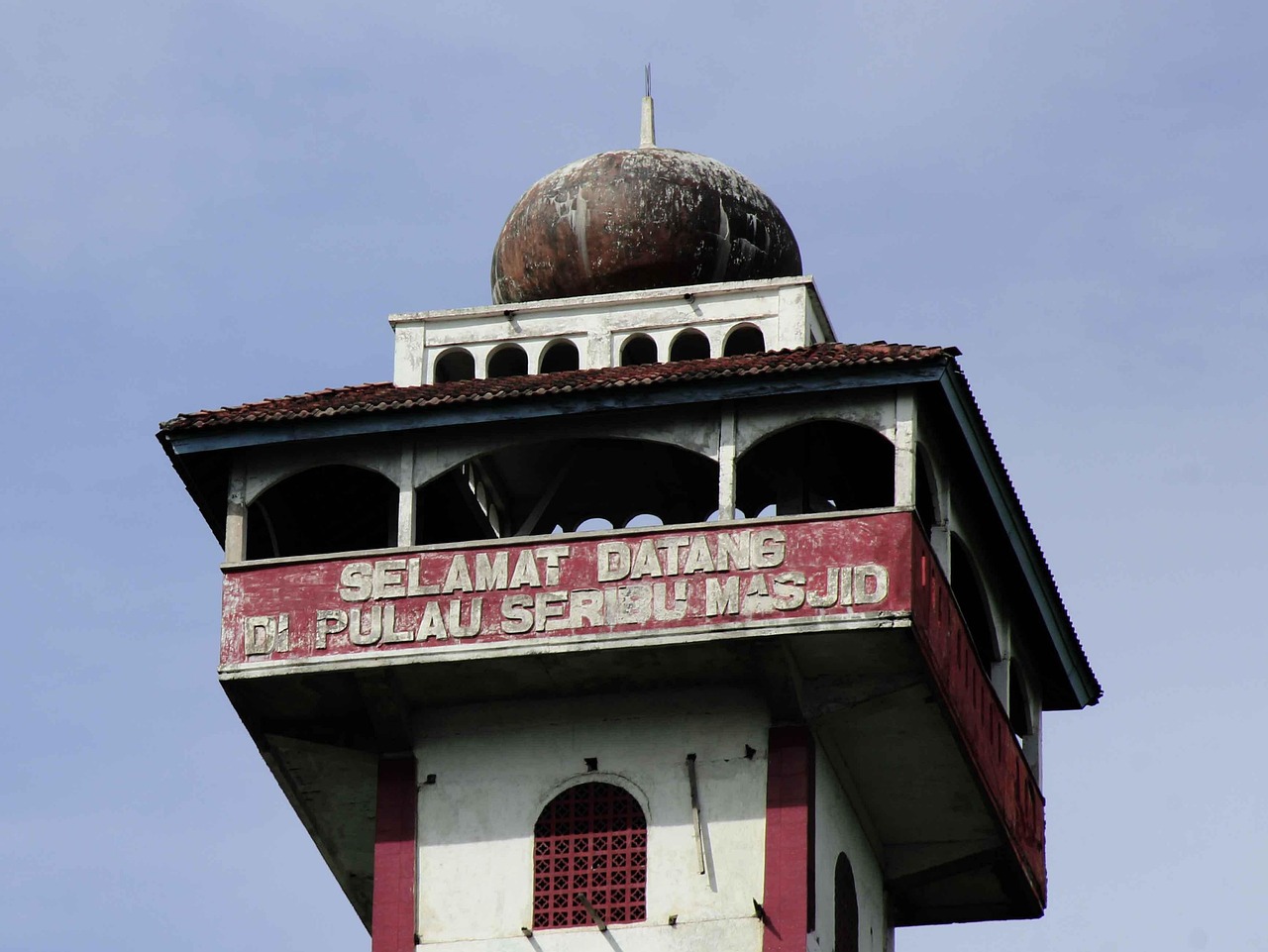 A mosque tower in Lombok carrying a welcome sign to the Island of a Thousand Mosques