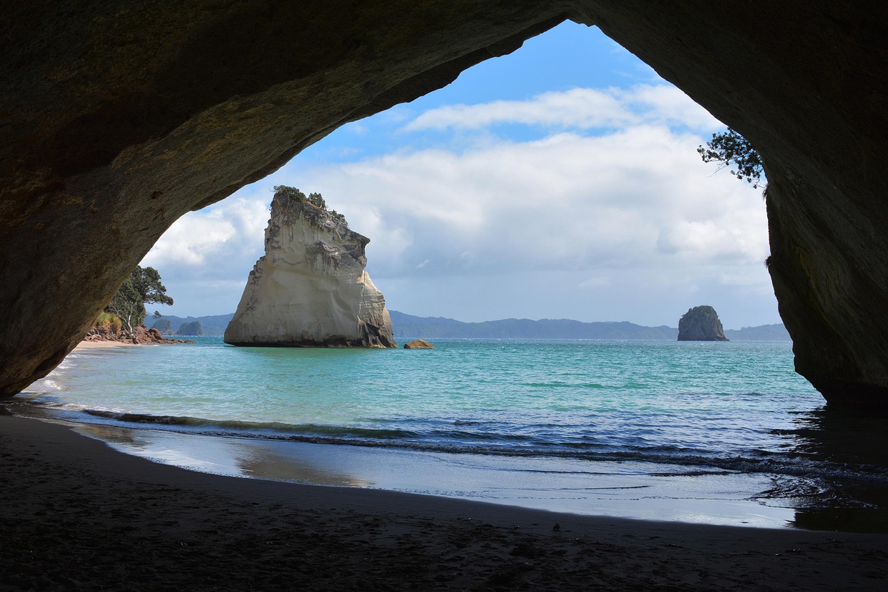 Cathedral Cove's iconic natural limestone archway frames turquoise waters, dramatic white rock formations, and pristine beach. 