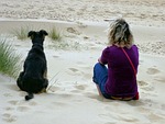 woman and dog, beach scene, sand