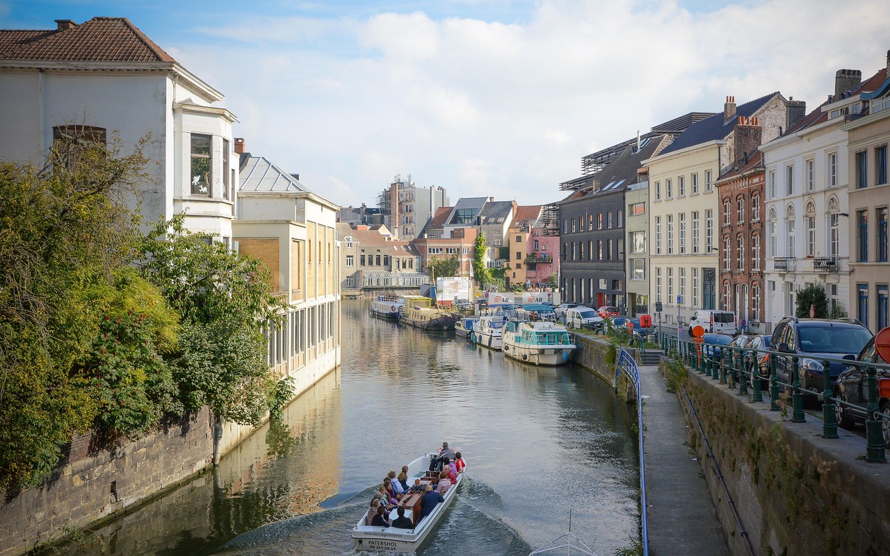 Ghent canal with historic merchant houses reflected in the water at golden hour