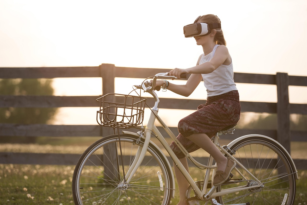 Young woman on a bicycle outdoors wearing an augmented reality headset.