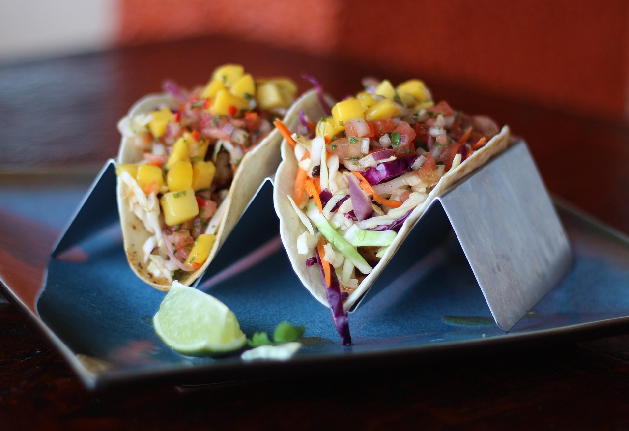 Fish tacos with cabbage slaw, mango salsa, and lime on a plate