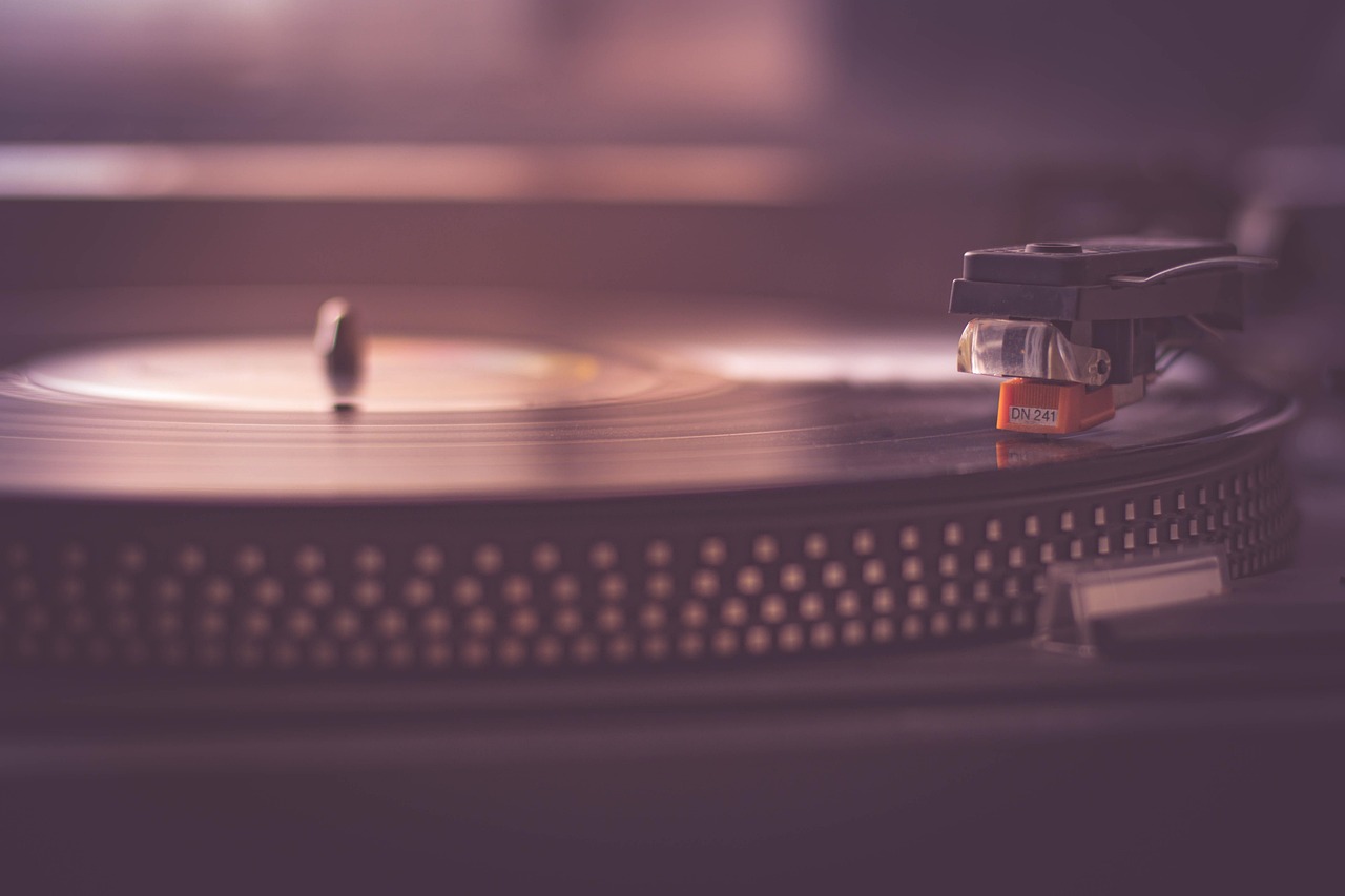 Vintage turntable with a vinyl record on a wooden surface.