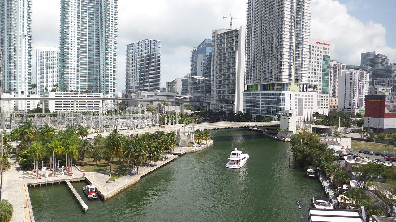 Miami waterway lined with high-rise condos and a yacht cruising past palm-lined docks