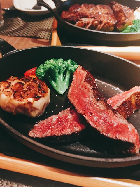 Sliced medium-rare ribeye steak showing a warm pink center and a dark seared crust