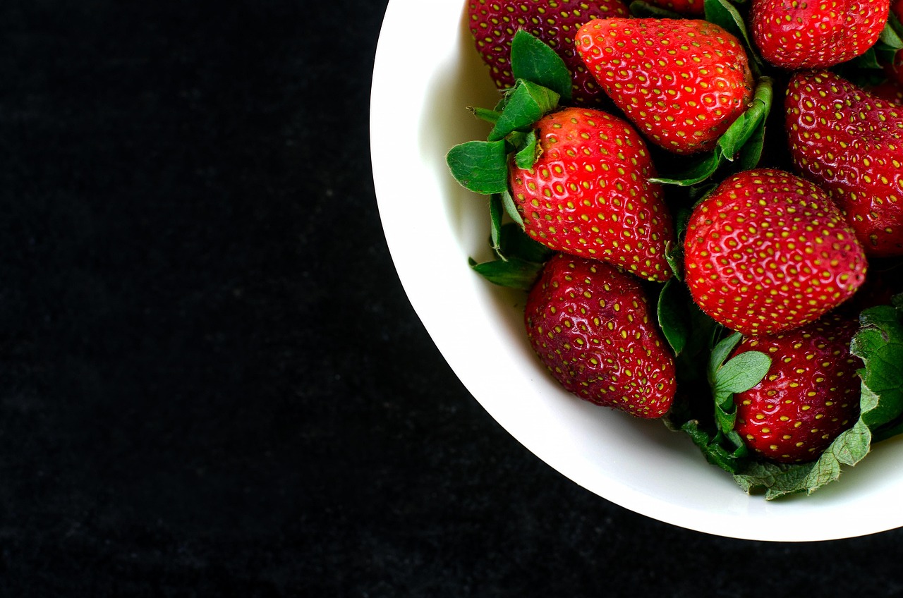 Fresh strawberries in a bowl, top view, ready for a frozen yogurt fruit cluster recipe