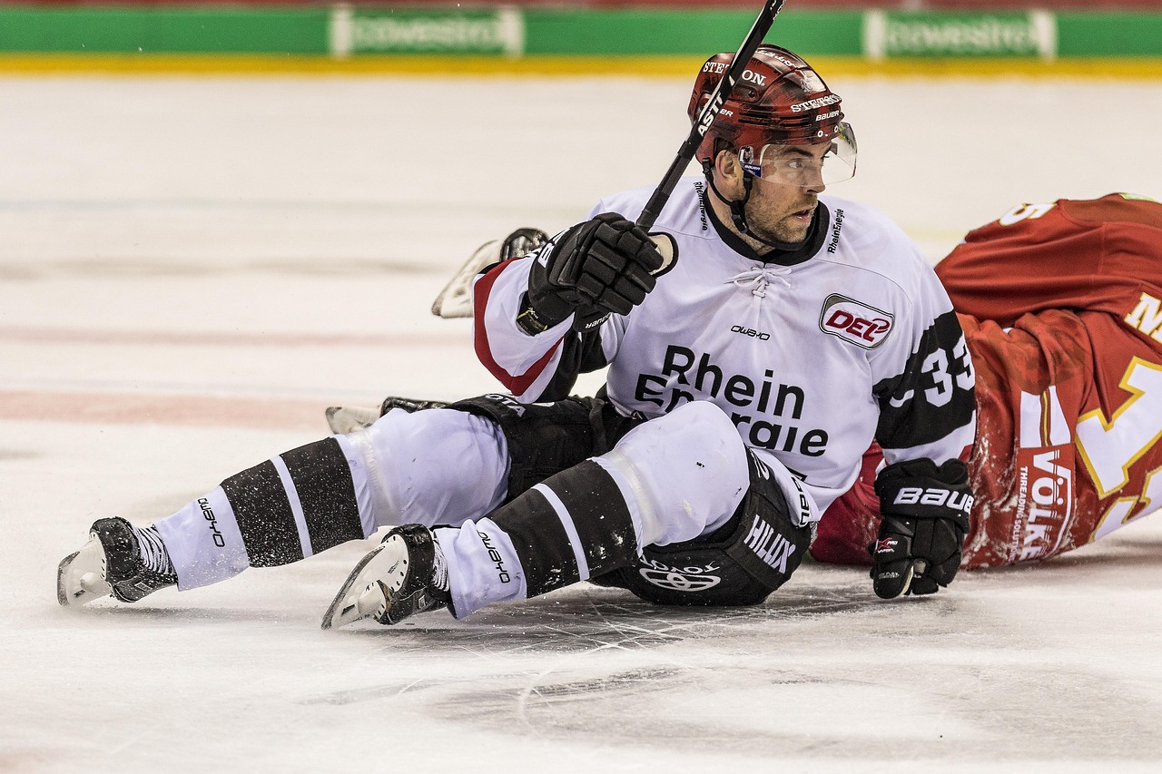 Ice hockey players battle for the puck during a game inside a packed arena