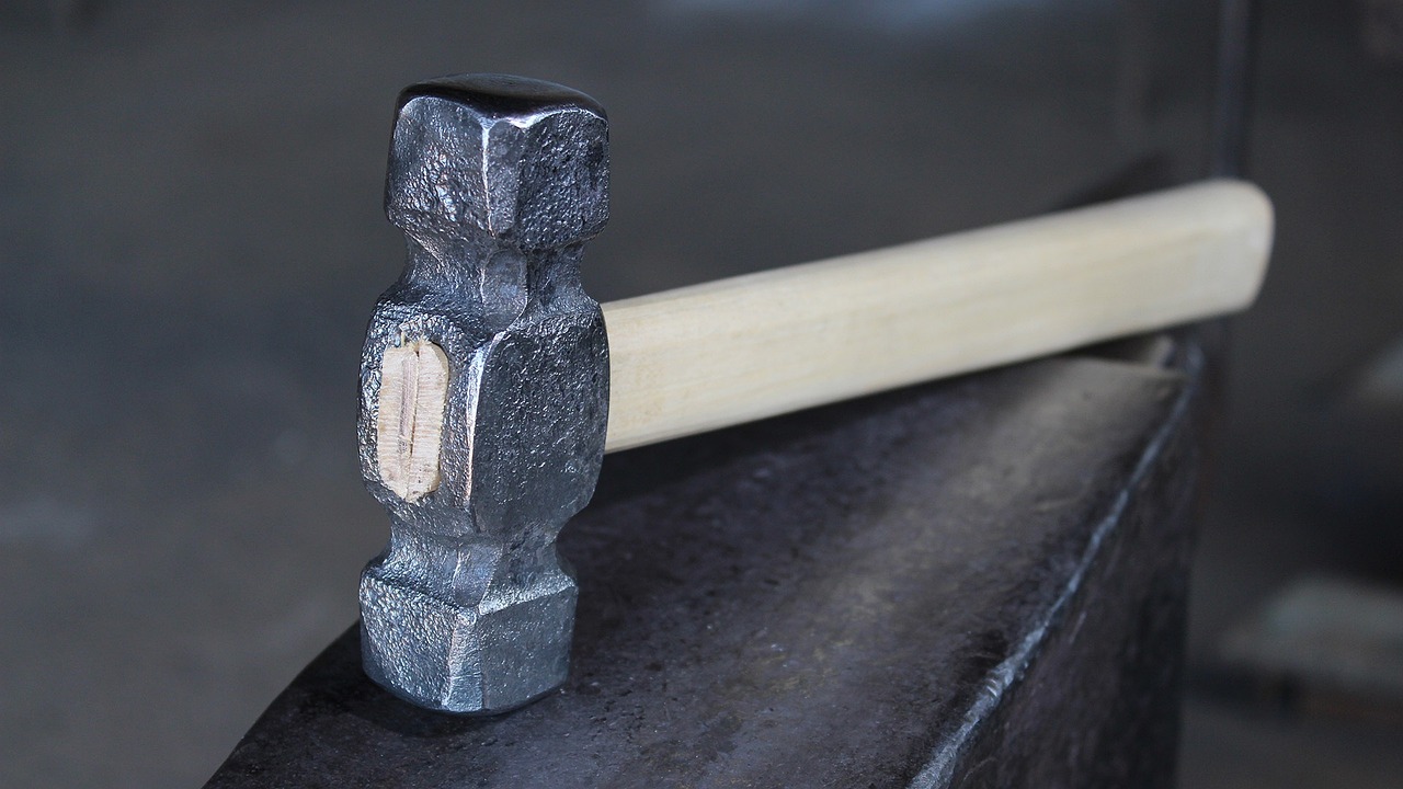 Metal hammer resting near a glowing forge in a blacksmith workshop.