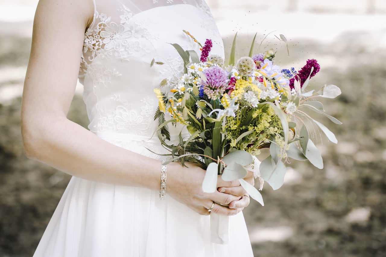 a bride holding a wedding bouquet made up of wildflowers