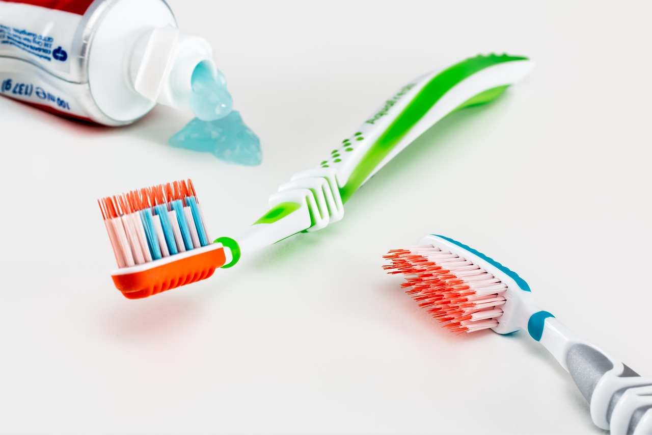 Toothbrush with toothpaste squeezed onto bristles against a white background.