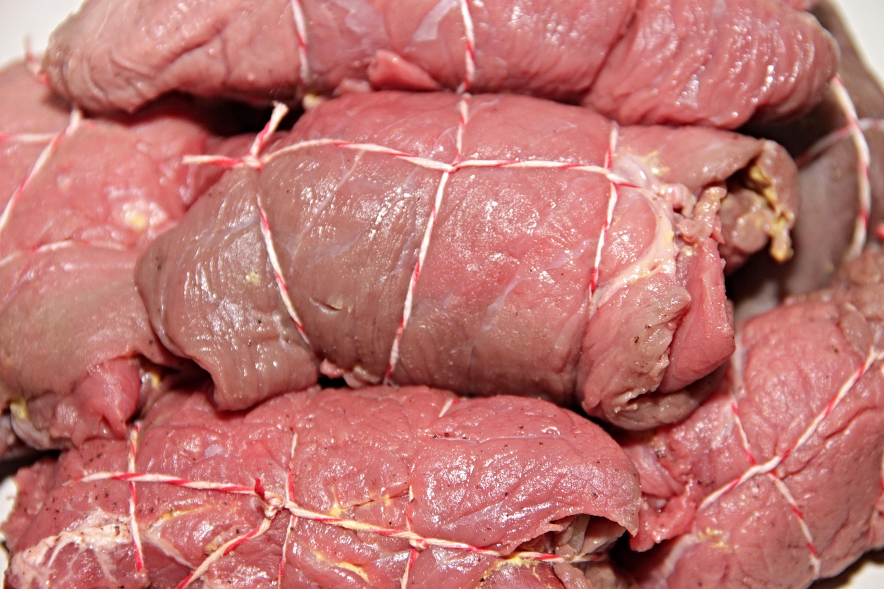 Raw beef roulades tied with kitchen twine, laid out ready to sear — the assembly stage of braciole.
