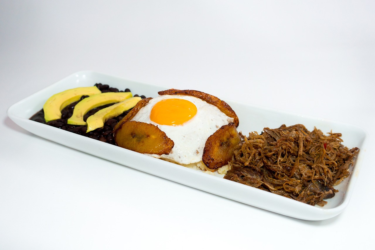 Bowl of Cuban ropa vieja shredded beef in tomato sauce with peppers, served over white rice