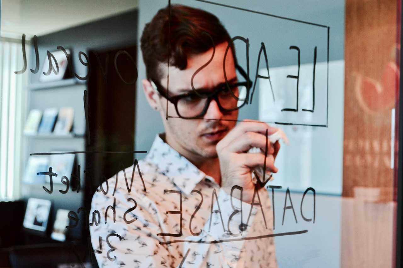 Marketing words and diagrams written on a glass surface with a blue marker.