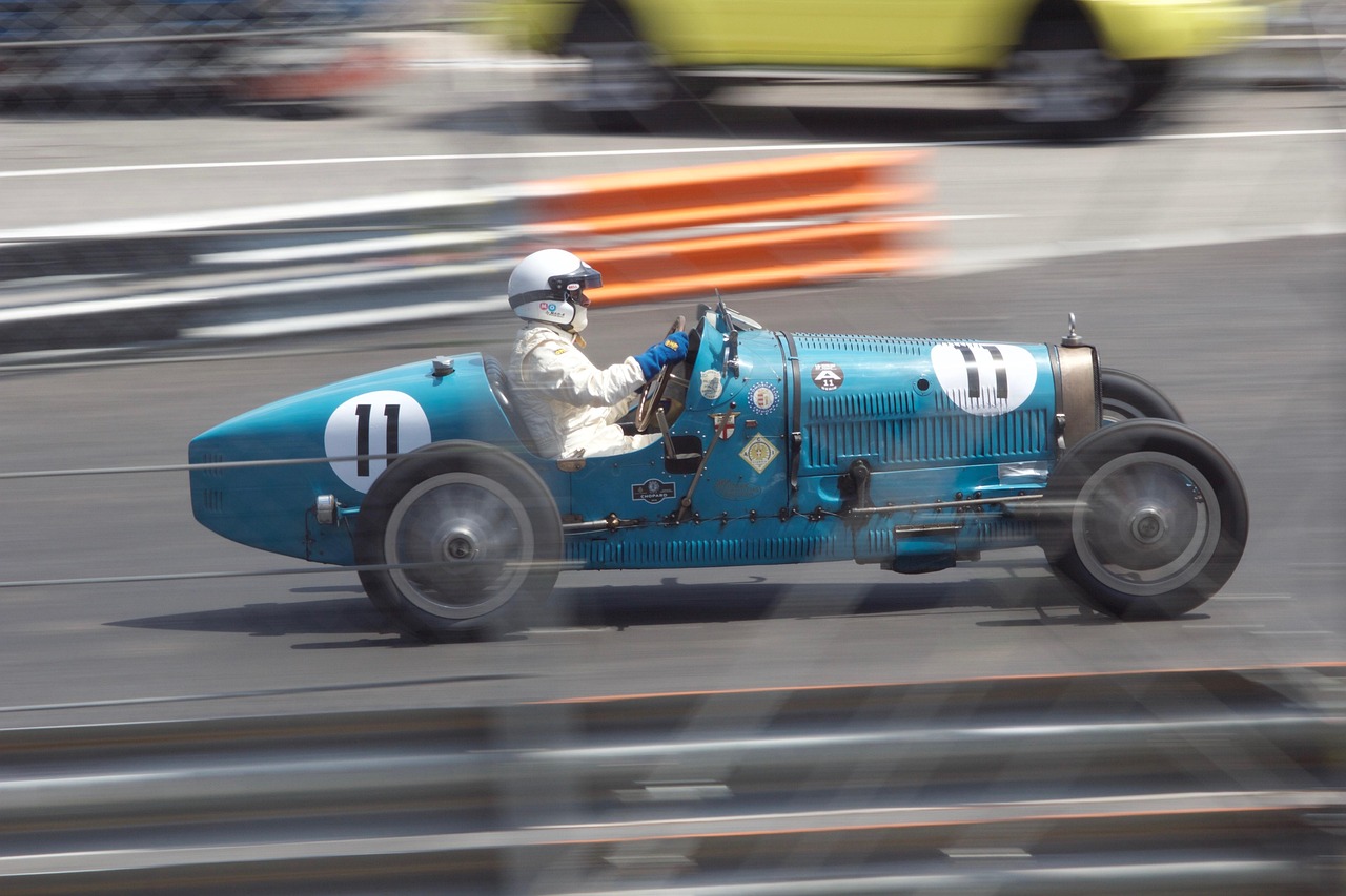 Formula 1 racing car on a street circuit with barriers and grandstands visible.