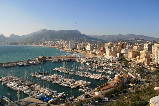 Alquiler de coches sin conductor en Calpe Vista de puertos con barcos, también playa y edificios, Alquiler de vehículos en Calpe VIVACARS