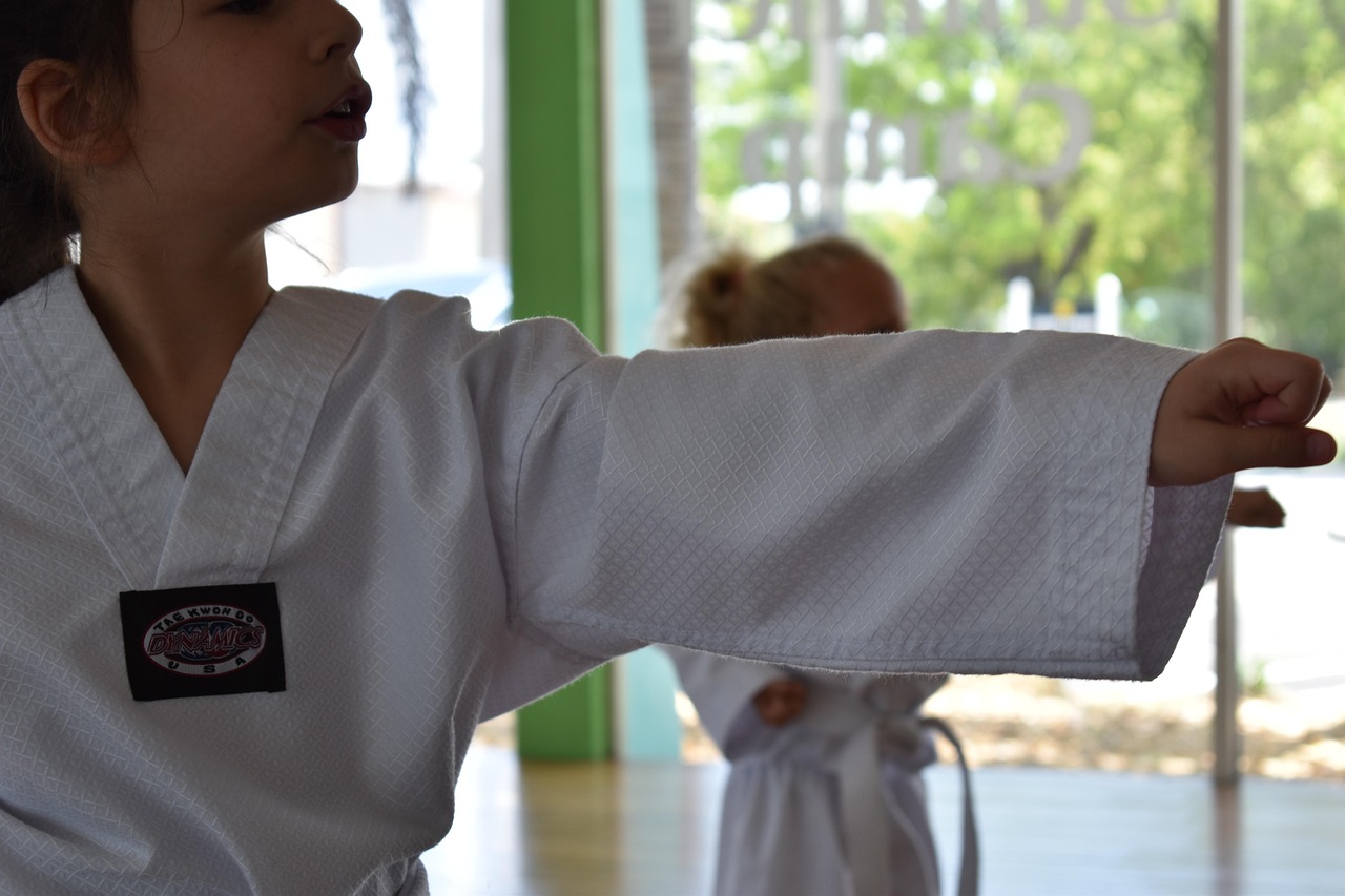 A person practicing martial arts, their body in motion against a serene backdrop.