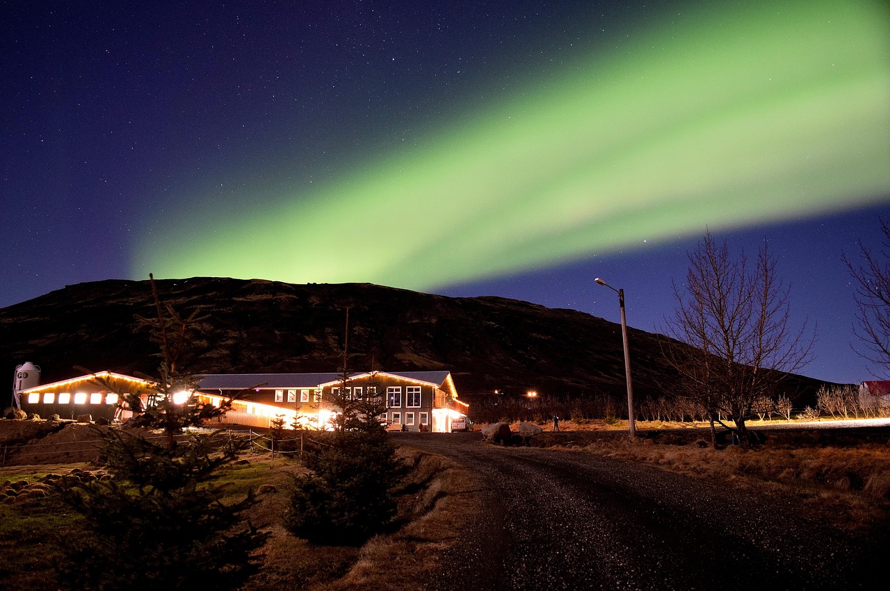 Northern Lights in the night sky over a lodge in Iceland