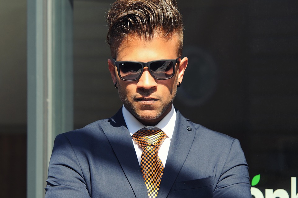 Man wears blue suit and shades