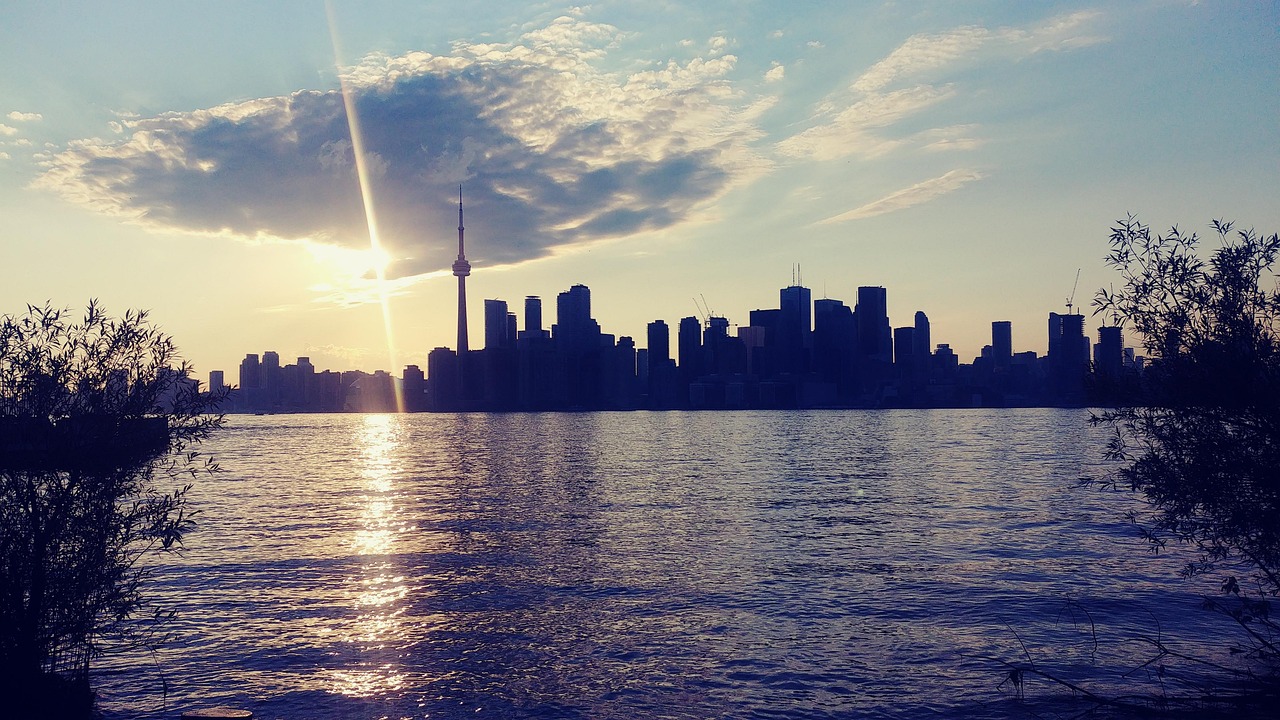 Toronto skyline with the CN Tower at sunset viewed across Lake Ontario, representing Canadian web hosting for Toronto businesses