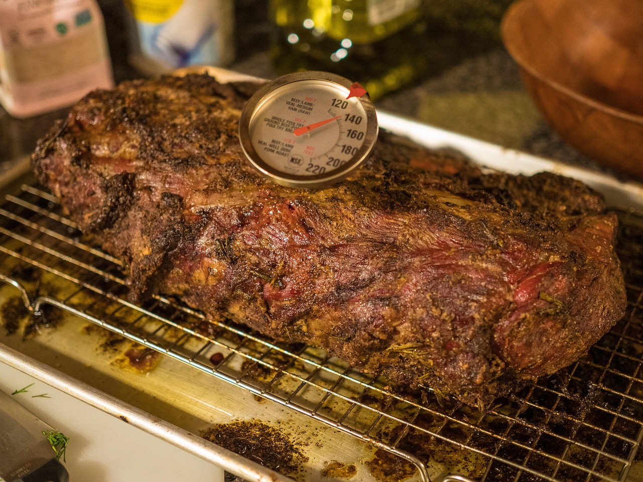 Roasted beef with a probe thermometer inserted into the thickest part of the meat