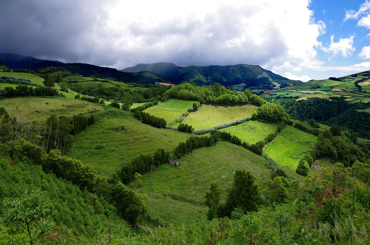 Misty Azores landscape with green hills and Atlantic Ocean in the distance