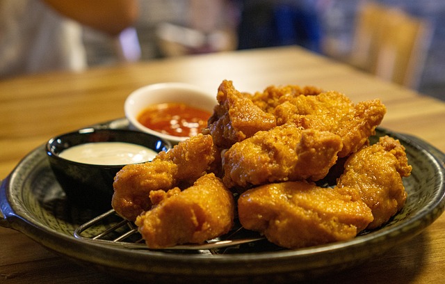 Golden chicken karaage pieces served with lemon wedges and shredded cabbage on a white plate