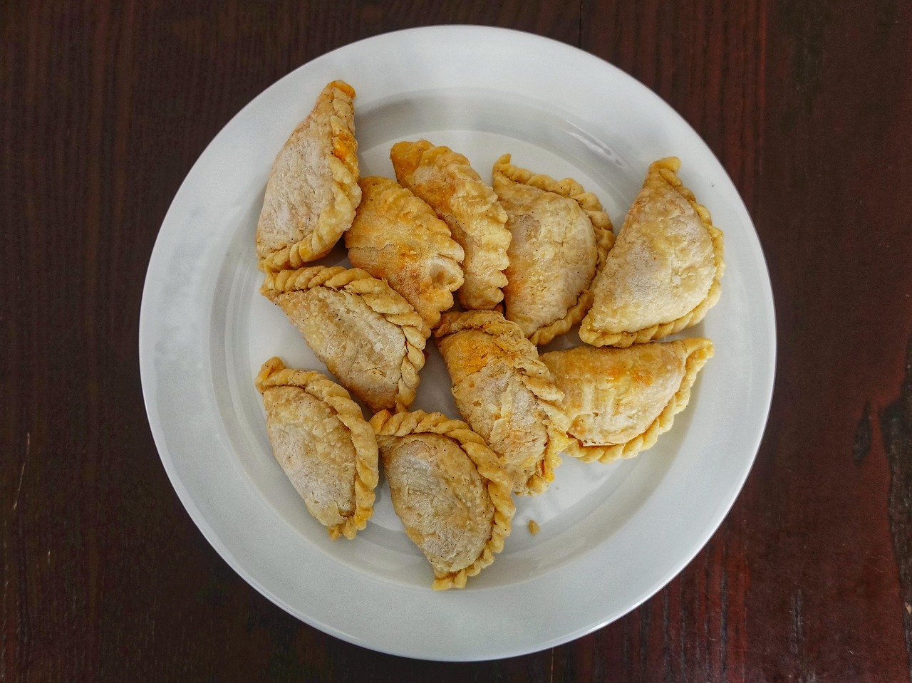 Curry pastry puffs on a plate with flaky pastry and curry filling