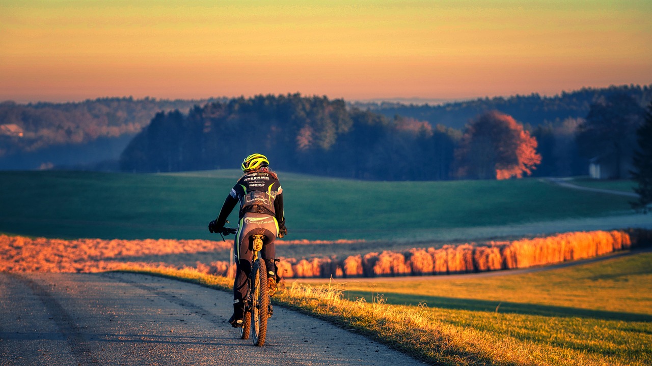 Wielrenner op een landelijke weg tijdens een lange duurrit in avondlicht