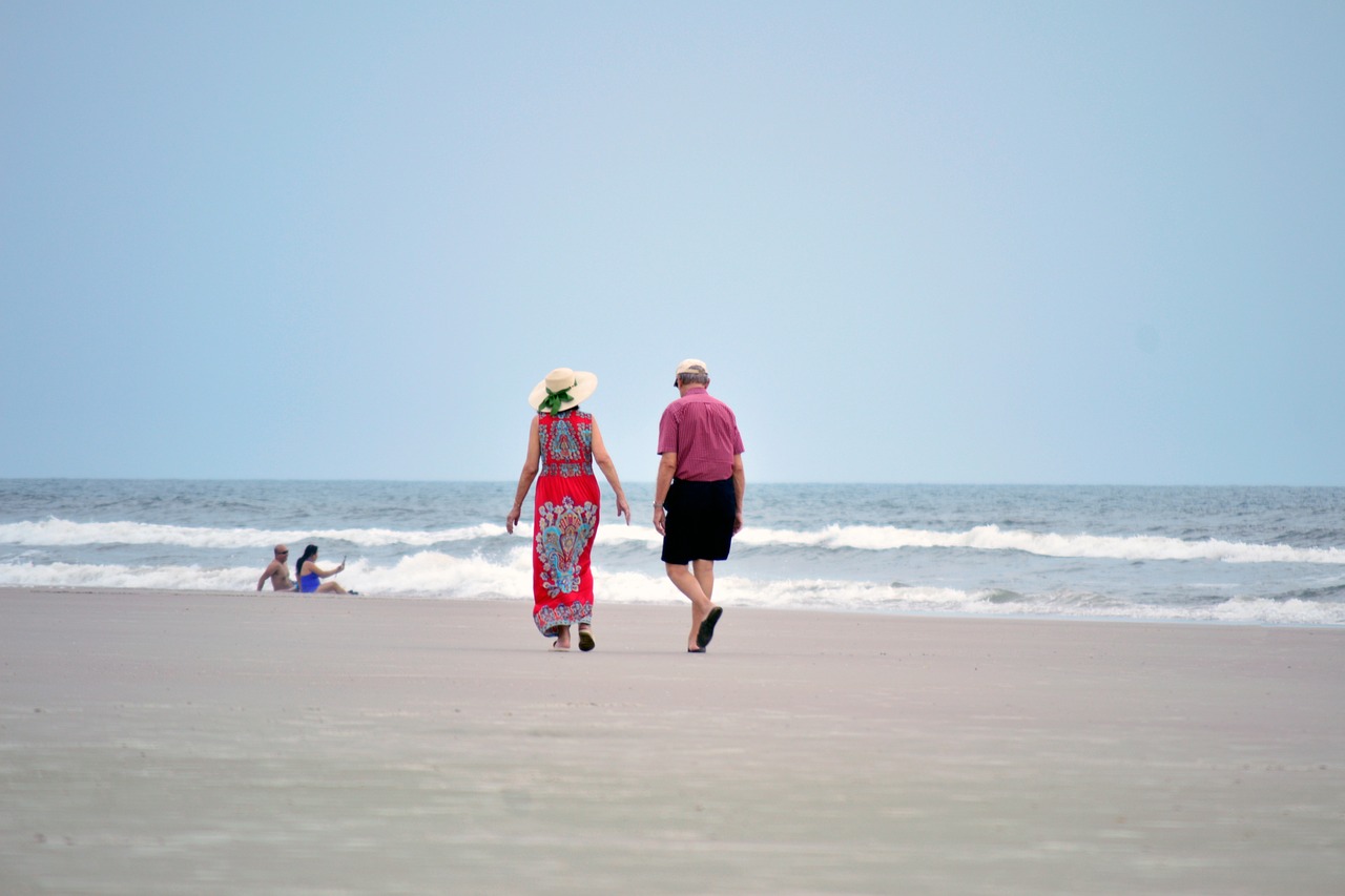 Retired couple walking together on a beach