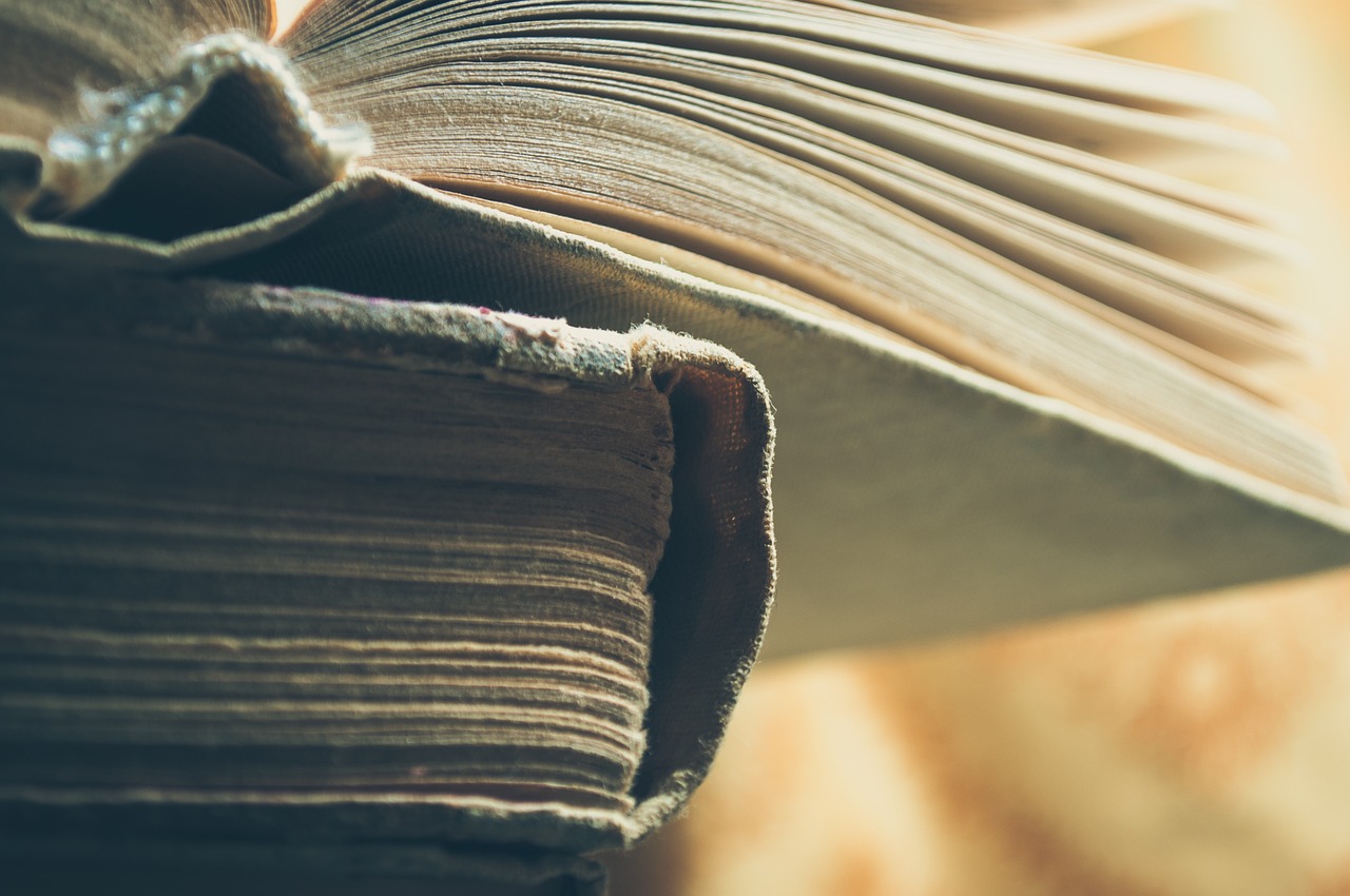 Stack of old worn books piled on top of each other.