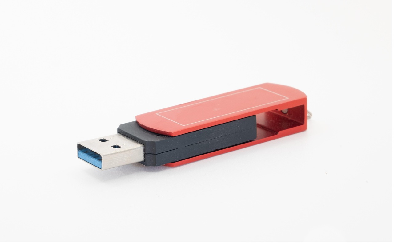 A USB memory stick standing upright against a plain background.