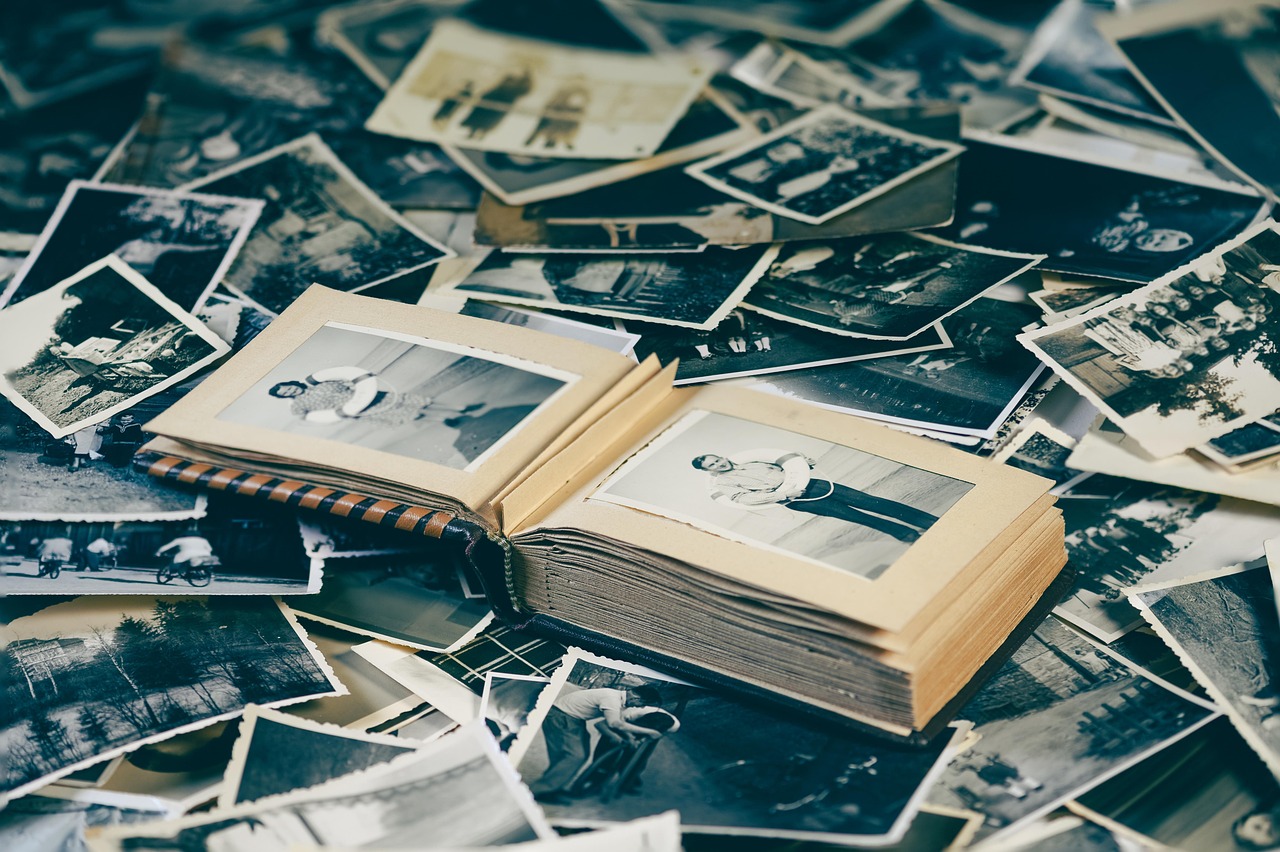 Scattered printed photographs fanned out, with a retro nostalgic look.