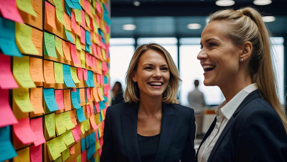 Two business professionals smiling in front of a wall covered in sticky notes