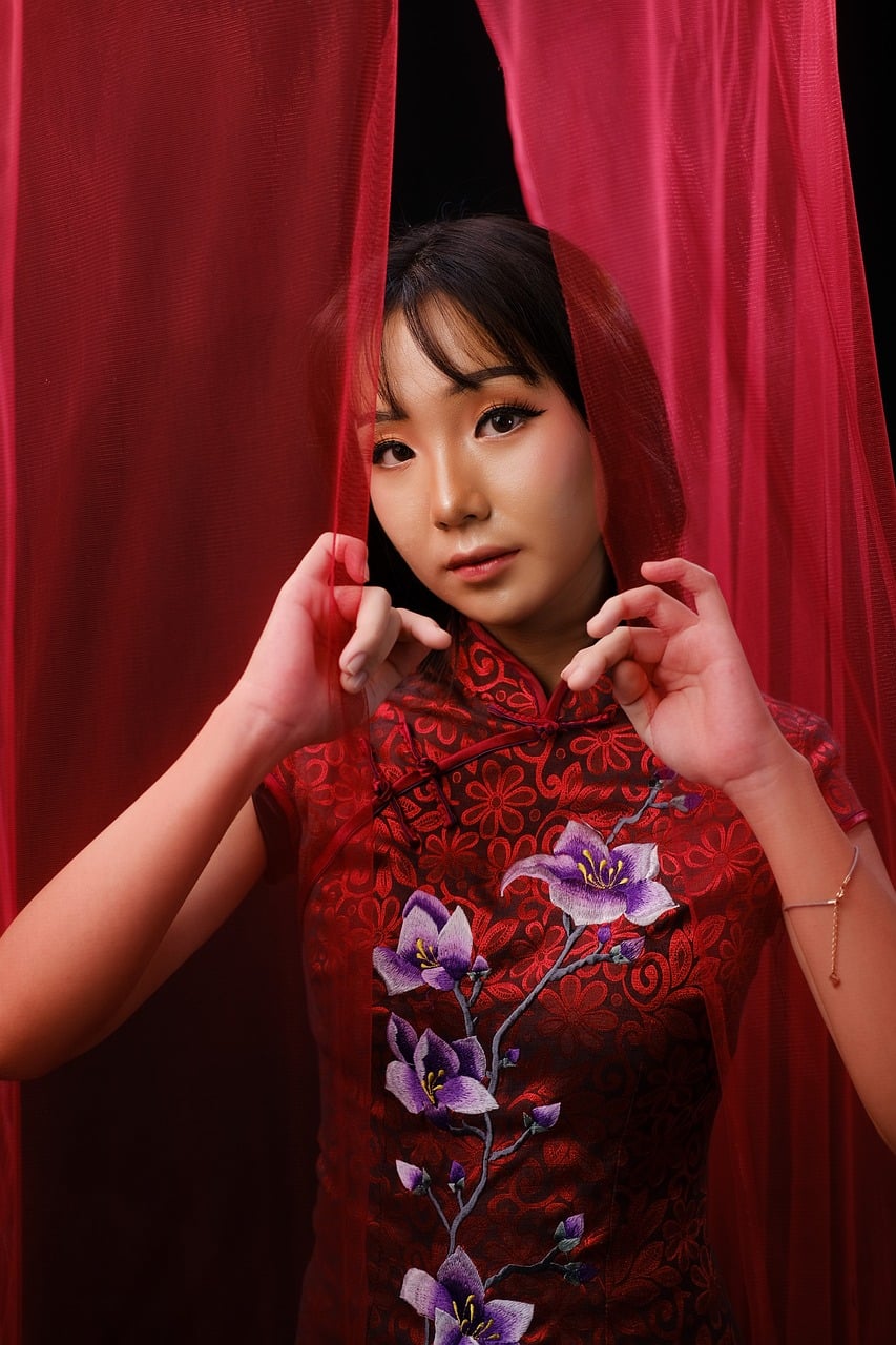 Woman in traditional Chinese cheongsam dress, capturing the elegance and embroidery heritage that inspires modern fashion accessories