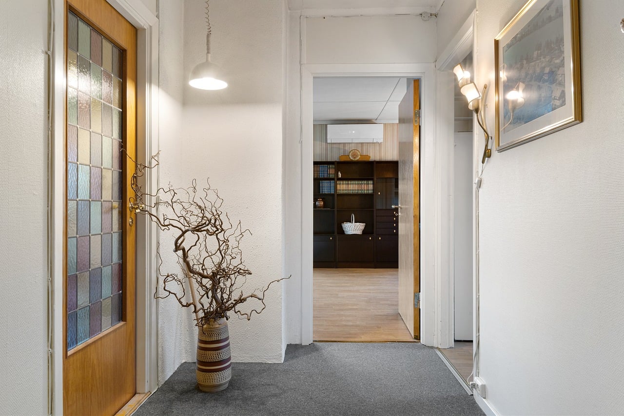 Warm lighting and textured decor in a narrow hallway entrance
