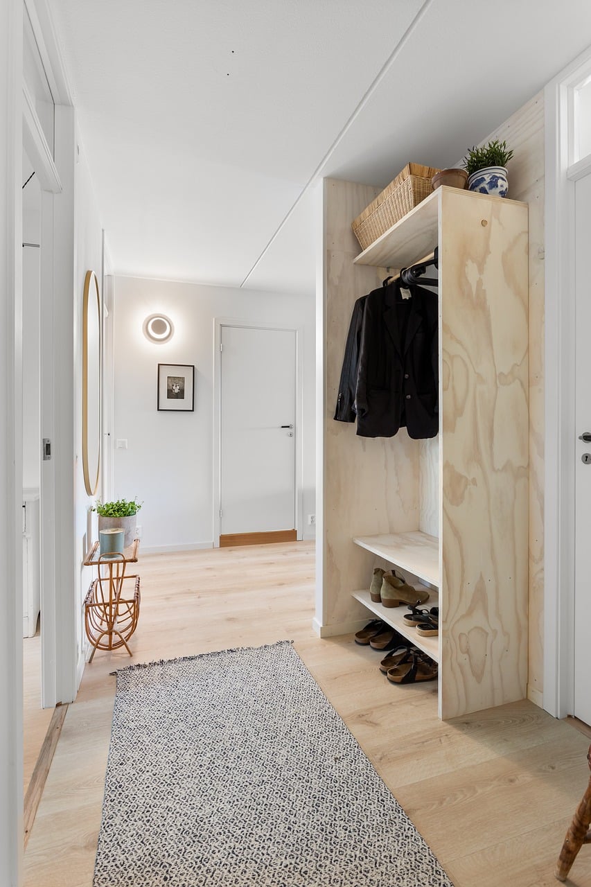 Wall mounted storage and hooks in a narrow entryway hallway