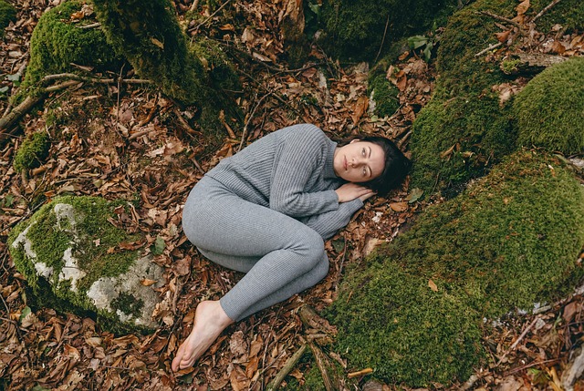 woman, forest, moss, leaves, autumn, nature, girl, grey, lying down, fetal position, barefoot, outdoors, vulnerability, solitude, peaceful, melancholic, connection, earth, woods, sweater, cozy, portrait, atmospheric, natural, serenity