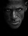 Random: portrait, black and white photo, expressive face, intense gaze, skin texture, man, strong lighting, art, detail, pose, emotion, contrast, strong facial features, dark tone, male model, deep gaze, photographic portrait, negative space, faces, black and white