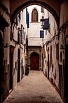 Random: morocco, essaouira, architecture, old alley, wooden door, blue shutters, stone path, street lamp, window, grand arch, city alley, historic building, romantic view, historical quarter, narrow architecture, street charm, eye for architecture, rocky urban terrain, completely deserted