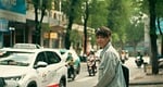 Random: city street, asian man, traffic, nature, motorcycle, taxi, denim jacket, backpack, trees, walking, traffic sign, summer afternoon, urban life, pedestrian, tropical country, slight smile, heavy traffic, urban style, lifestyle